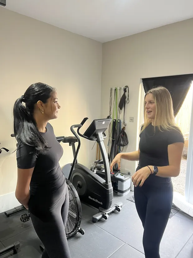 Ella talking with a client beside the bike before a session