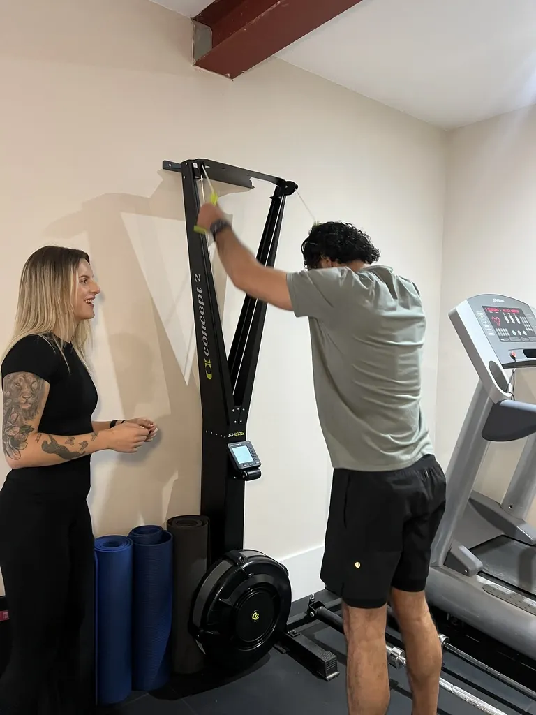 Ella coaching a client through intervals on the ski trainer