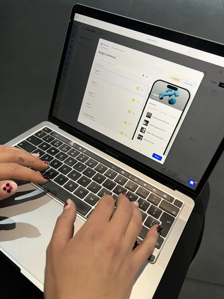 A client following their MoveWithElls plan on a laptop, with video demonstrations beside each exercise